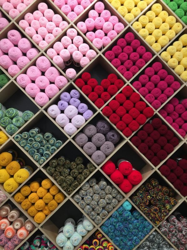 A vibrant arrangement of yarn in various colors organized on shelves, perfect for knitting or crafting.